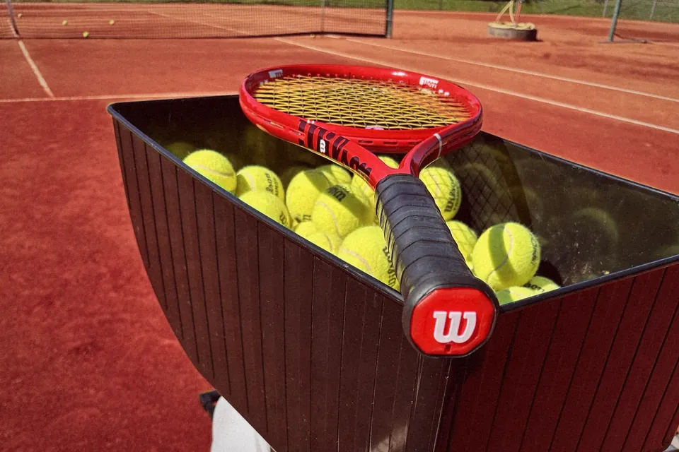 Roter Wilson-Schläger auf dem Ballkorb der Ballmaschine
