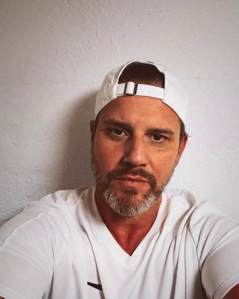 Greg heute, Porträt mit weißer Cap und Bart